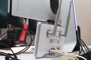 A WiFi network adapter and cords viewed from behind a desktop computer.